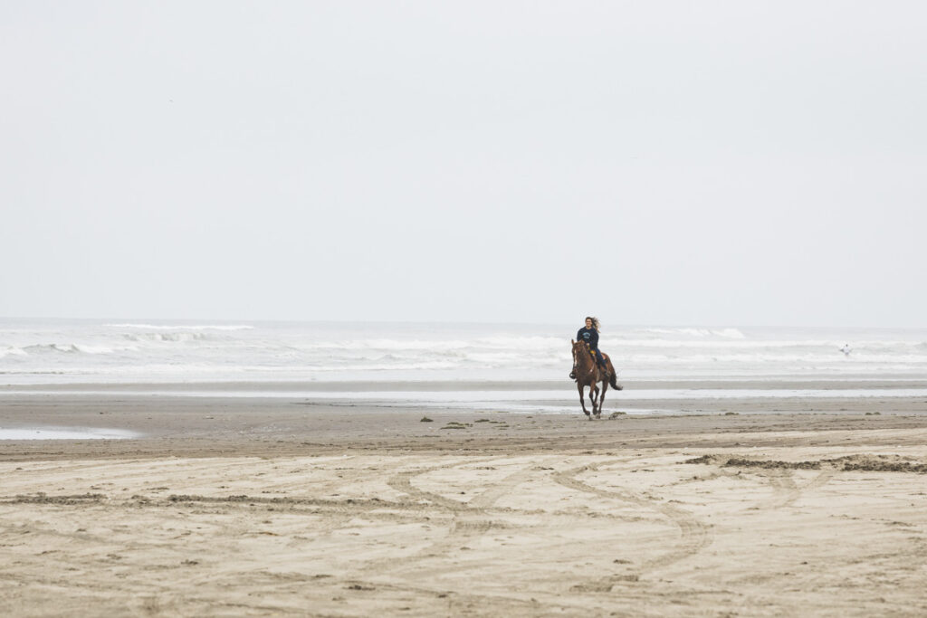 Woman riding horse at Long Beach, Washington