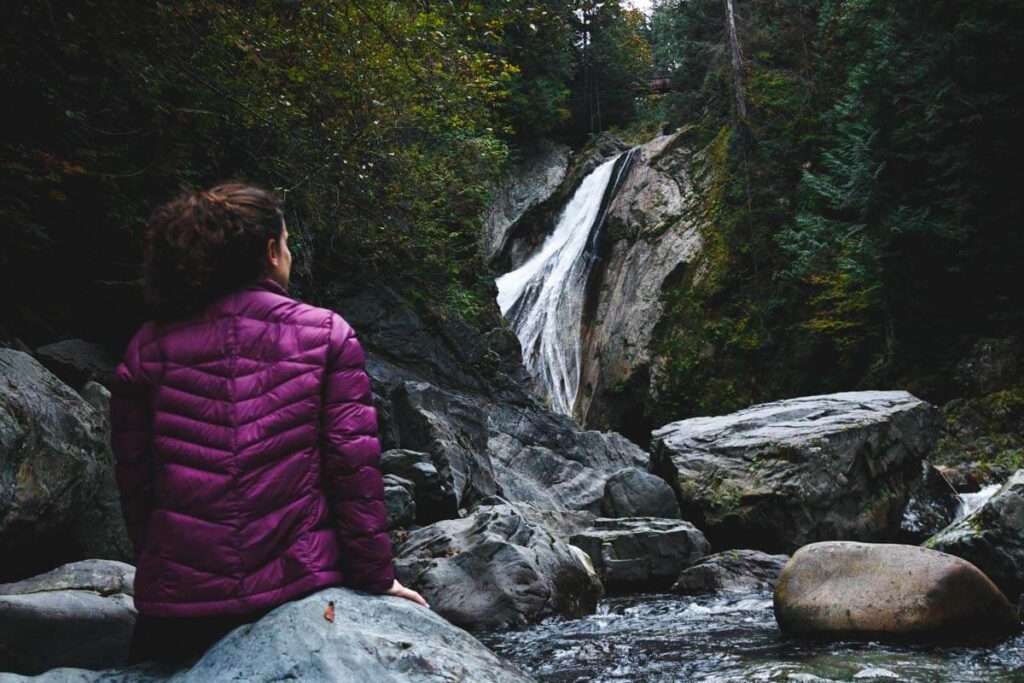 Woman sitting on rocks in front of Twin Falls near Seattle