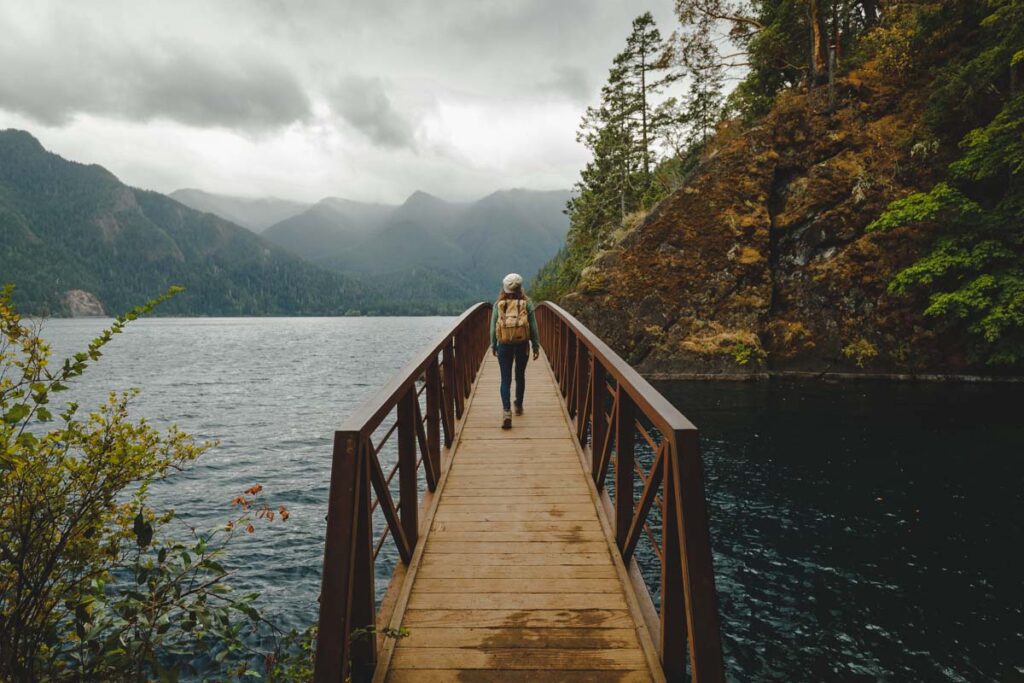 Hiker crossing wooden bridge on the Devil's Punchbowl on a day trip from Seattle