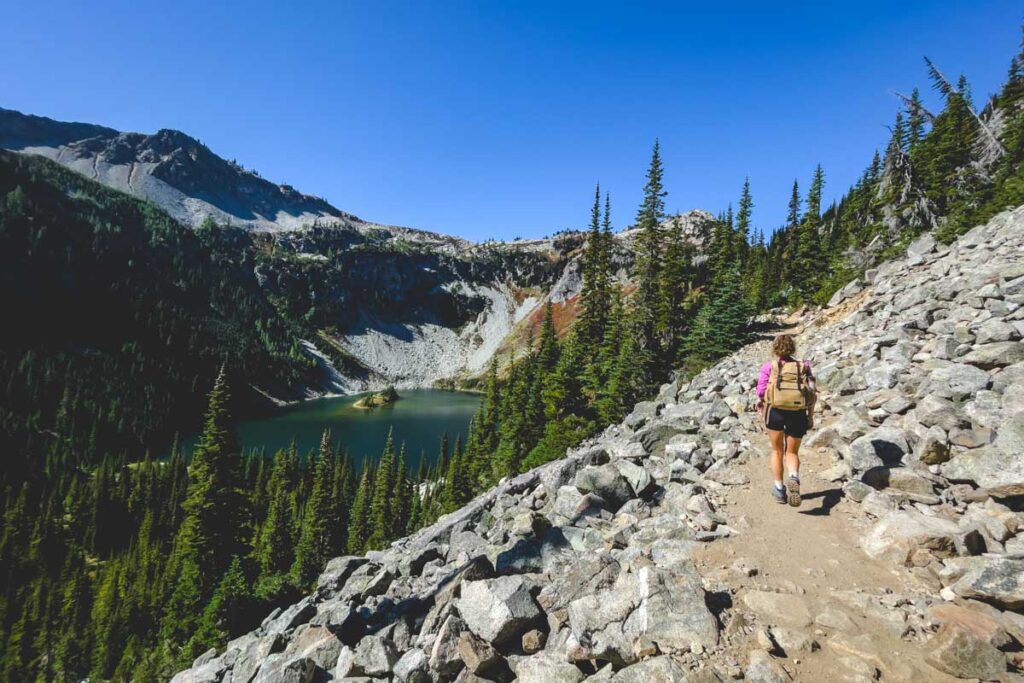 Hiker passing lake on the Maple Pass Trail