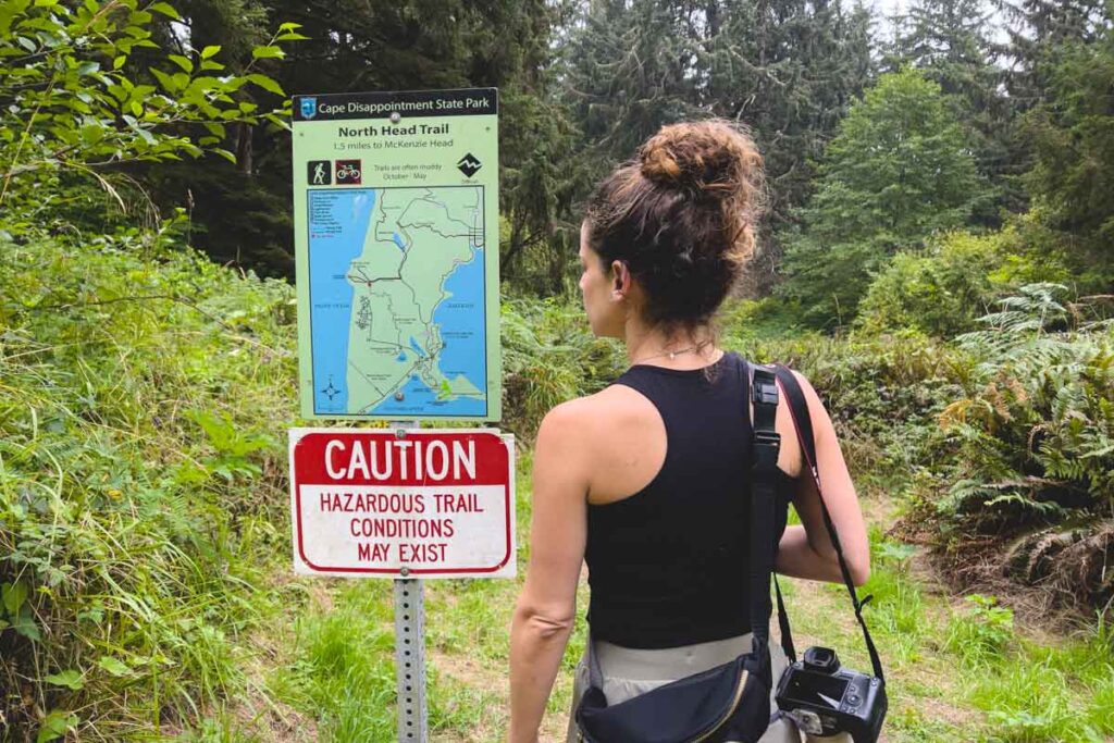 Woman at sign for North Head Trail in Cape Disappointment State Park