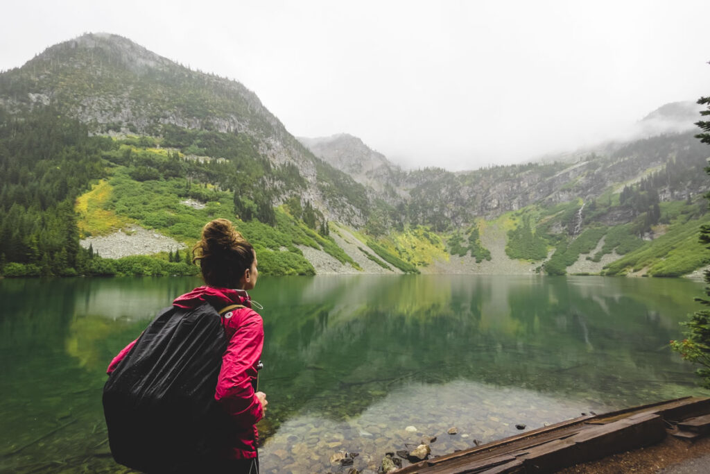 Hiker at lake on the Rainy Lake Trail near Maple Pass Loop