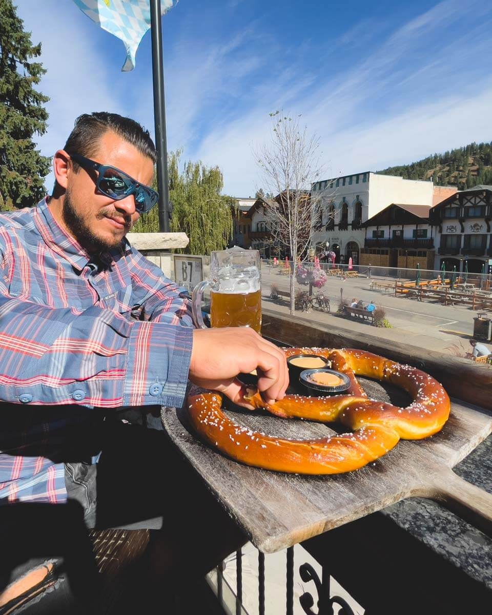 Garret eating a giant pretzel on a sunny day in Leavenworth.