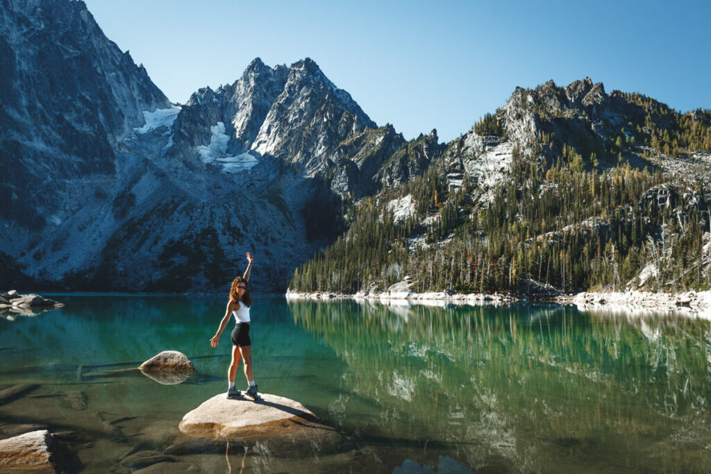 Woman on a still, blue lake found while hiking The Enchantments in Washington.