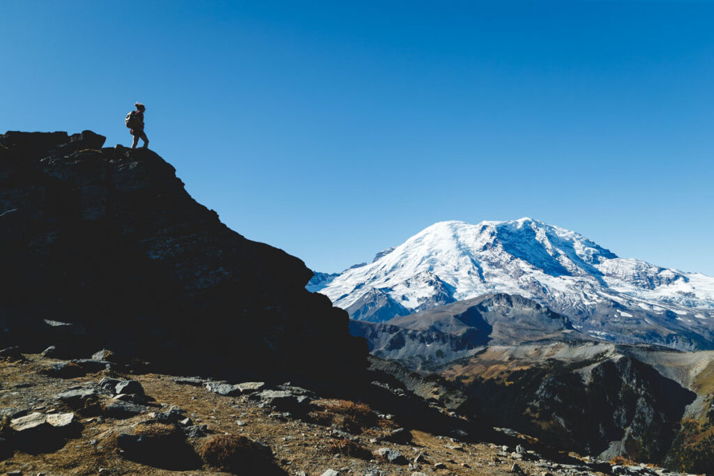 Hiker on rock with view of Mount Rainier from the Mount Fremont Lookout Trail