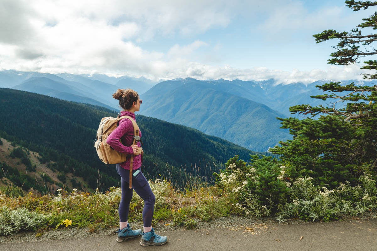 Nina hiking along Hurricane Ridge in her hiking gear enjoying the view over the valley.