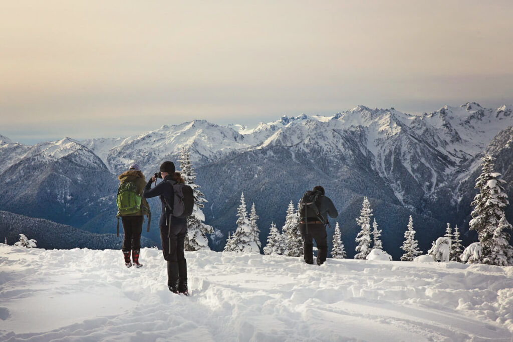 Hikers on snowy mountain summit in Olympic National Park, Washington in winter