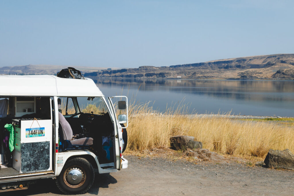 An old VW campervan parked at the shoreline of Soap Lake in Washington.