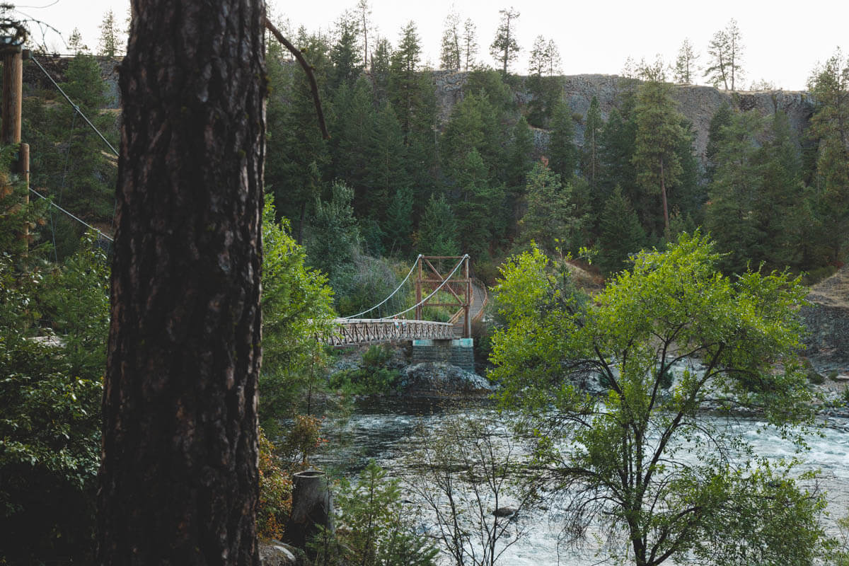 Two hikers crossing the suspension bridge in the Bowl and Pitcher area.