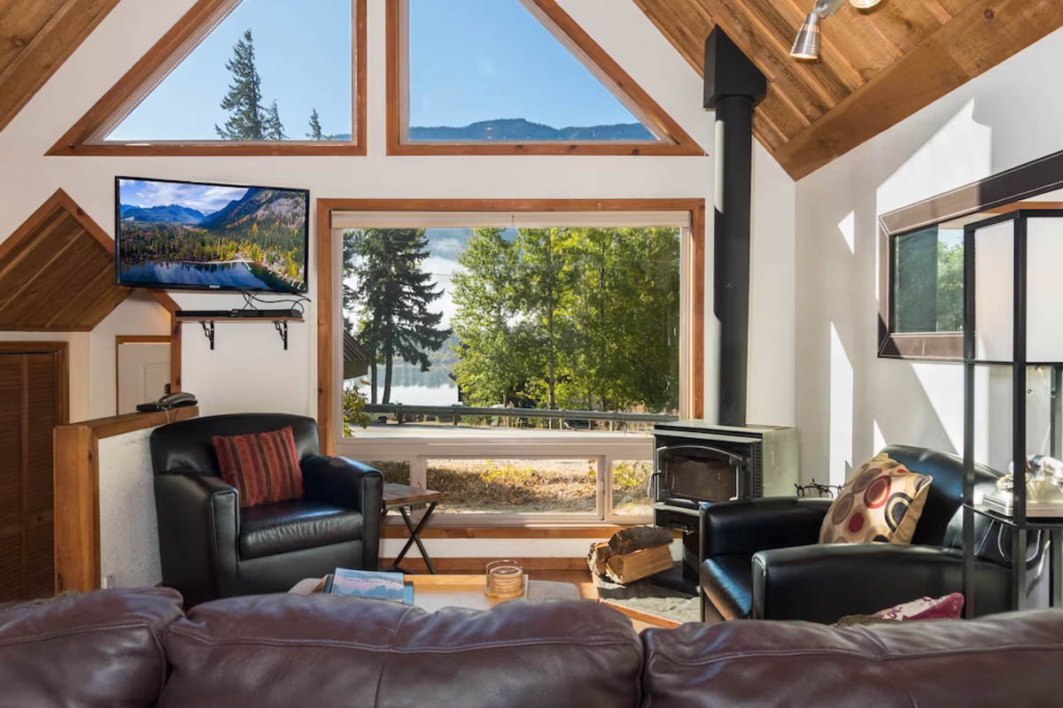 The beautiful living area of Vista View Chalet in Washington with a view through the window looking at the surrounding forests and mountains.