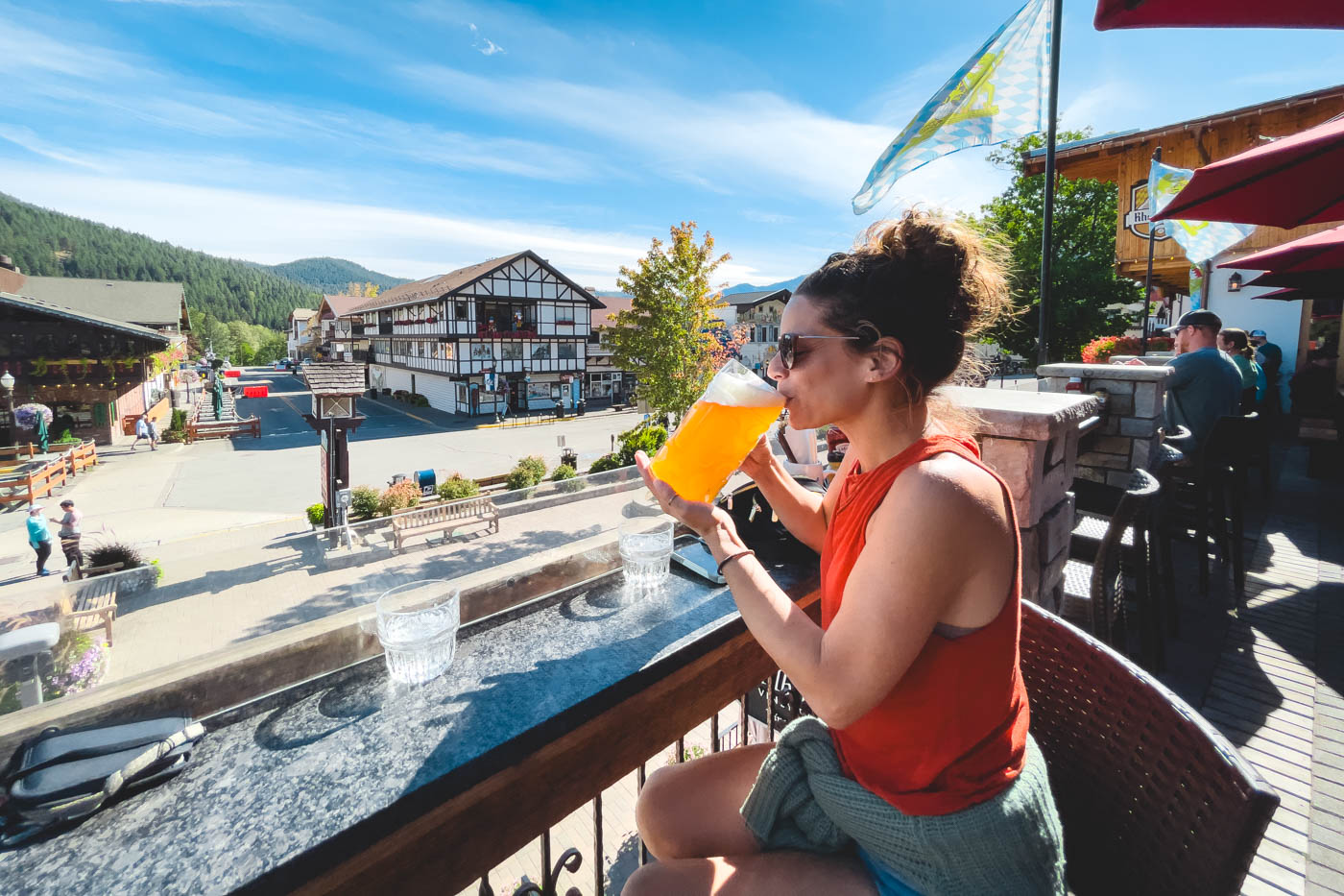 Nina sipping on a giant stein of beer while overlooking the center of Leavenworth from a balcony.