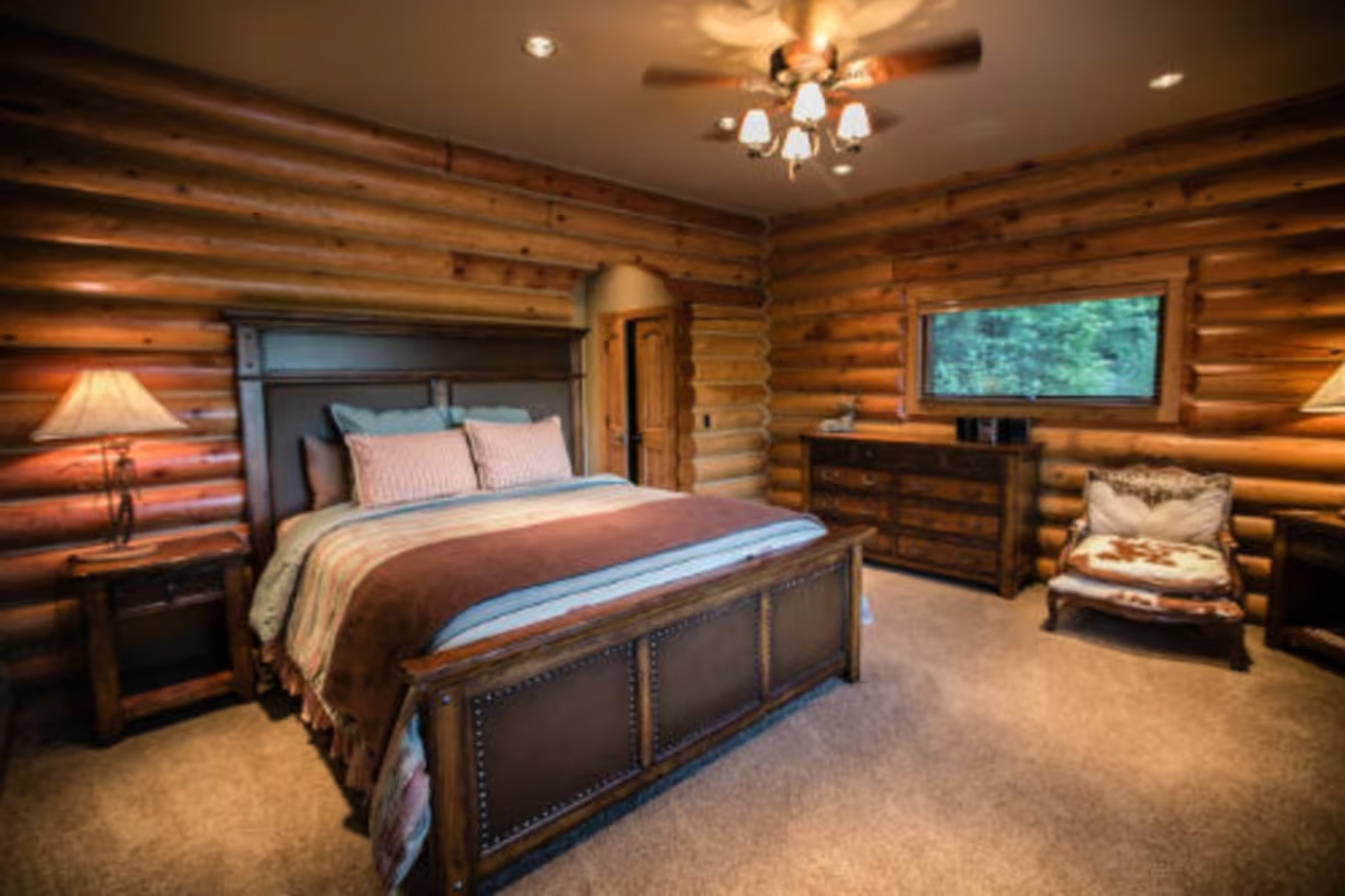 A clean and tidy double room with a log finish to the walls inside Lux Lodge.