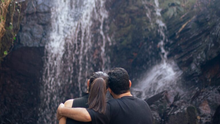 A couple enjoying a waterfall together.